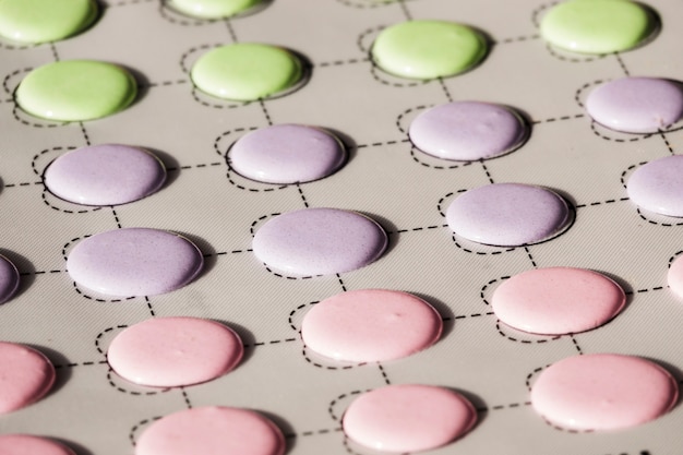 Green; pink and purple macaroons shells on a slip mat