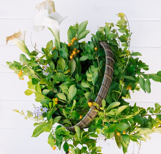 Green plant twigs and flowers in hamper