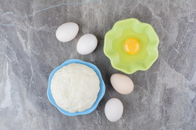 Зеленая тарелка сырого яйца и куриных яиц. Фото высокого качества