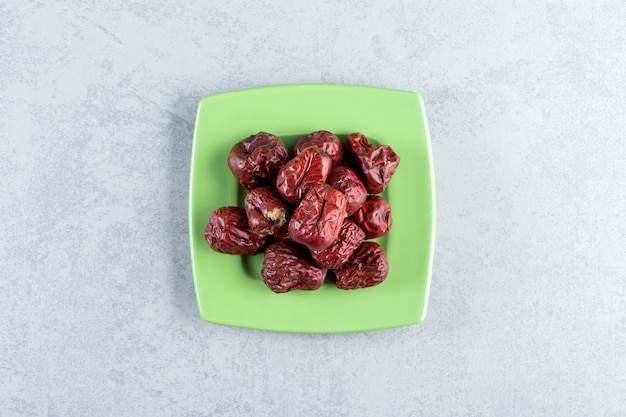 Free photo green plate of tasty ripe silverberries on marble background.