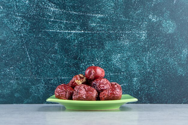 Green plate of tasty ripe silverberries on marble.