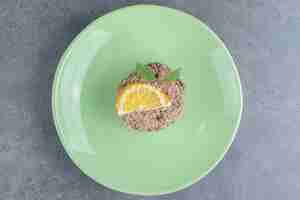Foto gratuita un piatto verde con cupcake e fetta di limone