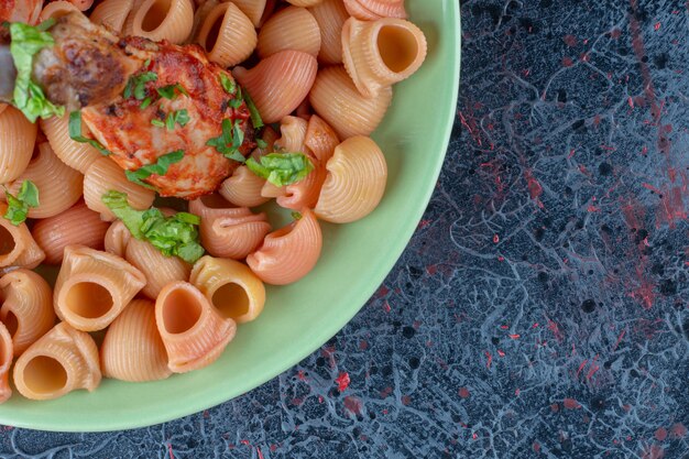 Free photo a green plate with fried chicken legs with macaroni .