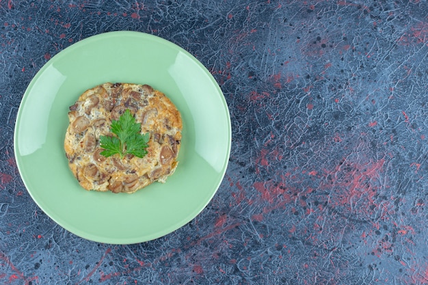 A green plate with fried egg and meat . 