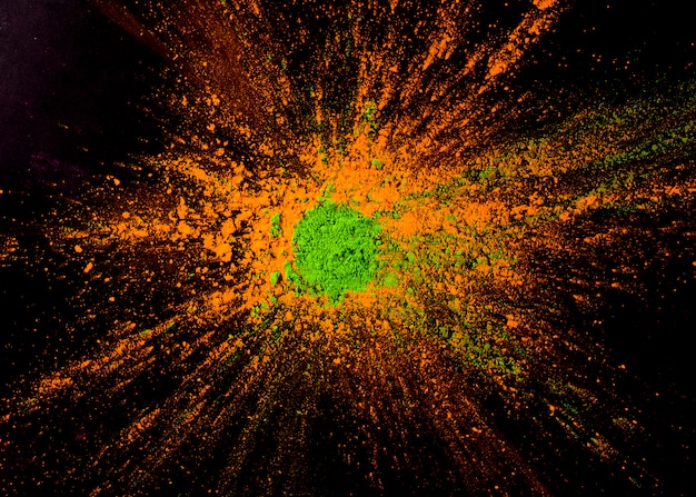 Foto gratuita colore della polvere verde su colore arancione sullo sfondo nero