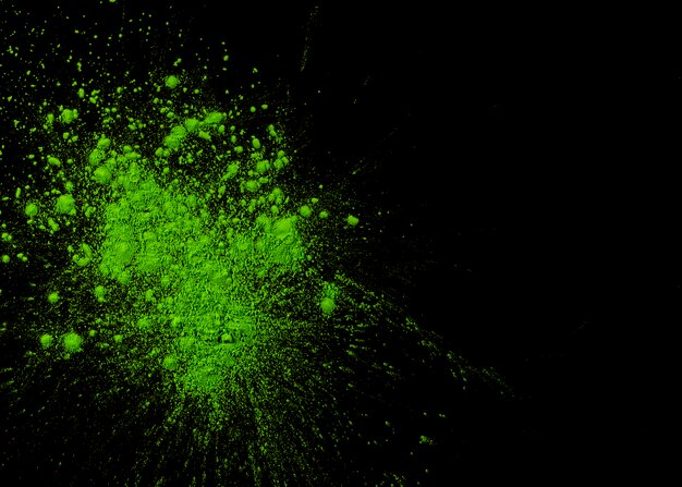 Green powder holi color over black background