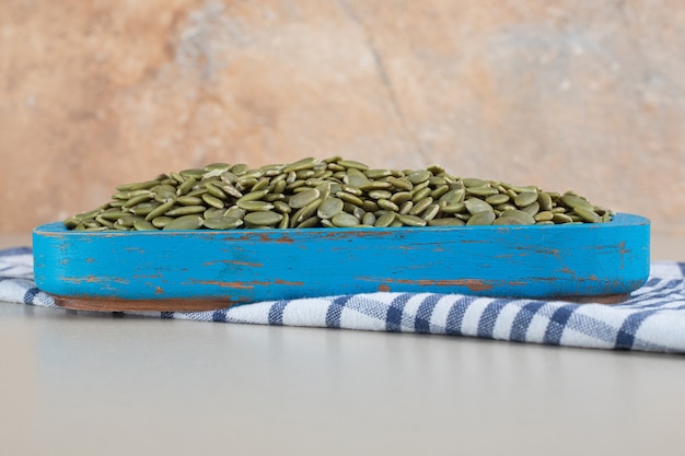 Green pumpkin seeds isolated on concrete.