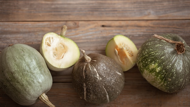 Free photo green pumpkins on a background of wooden boards top view close up. autumn harvest concept.