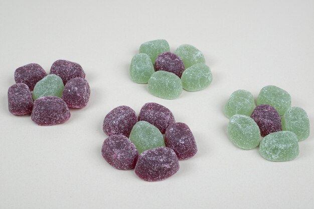 Green and purple jelly candies on beige surface