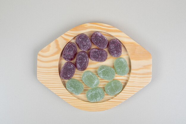 Green and purple jelly candies on wooden plates