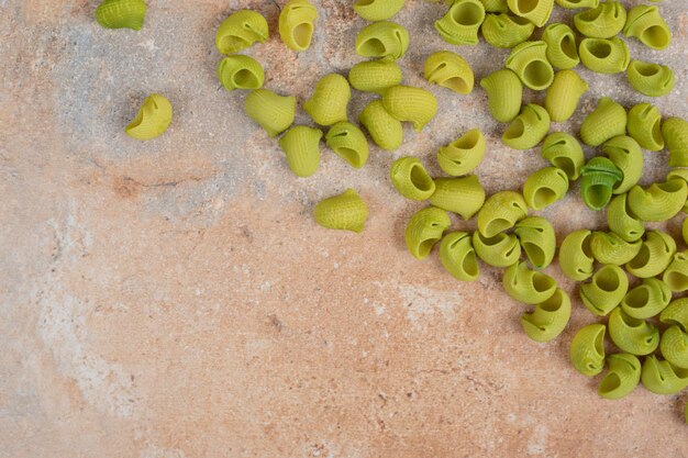 Green raw pasta on marble space. 