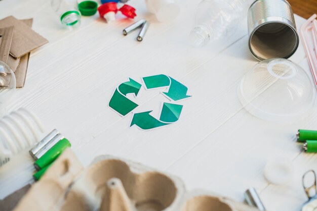 Green recycle symbol surrounded with waste items