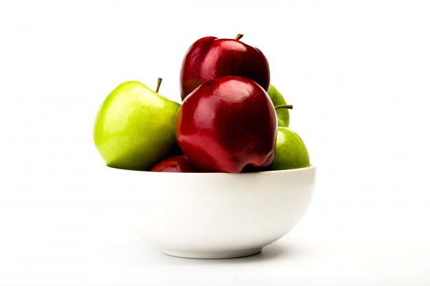 Green and red apple on plate isolated on white background