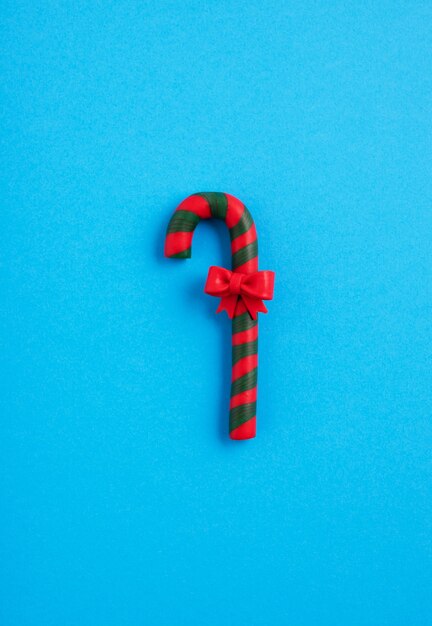 青の背景、クリスマス気分の弓と緑と赤のキャンディケイン