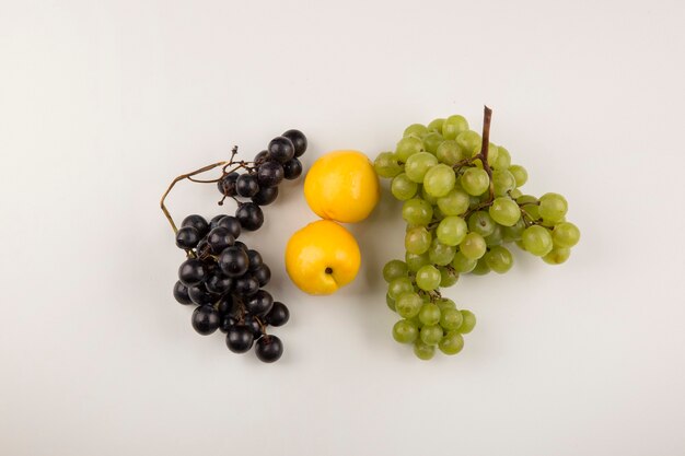 Green and red grape bunches with yellow peaches in the center