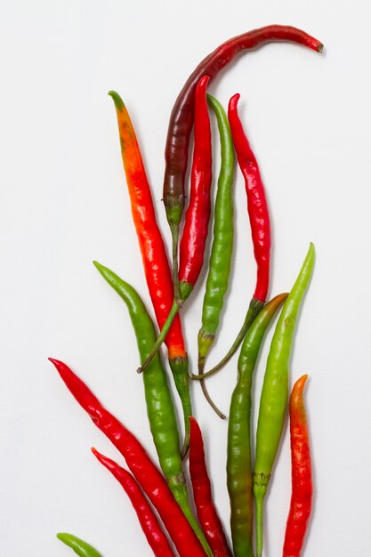 Green and red peppers on plain background