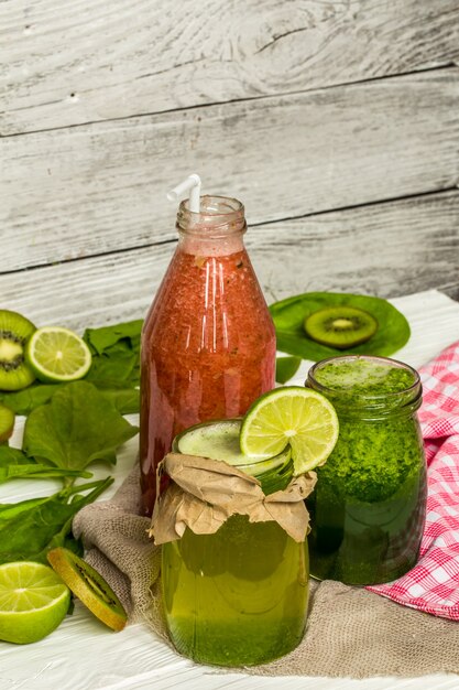 green and red smoothies in a jar with lime, kiwi