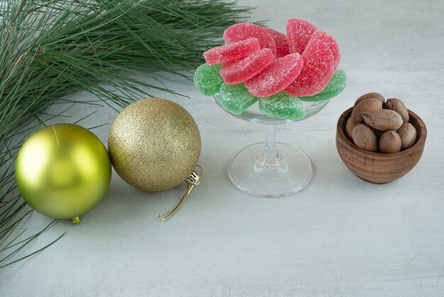 Green and red sugar marmalade with Christmas balls on white background. High quality photo