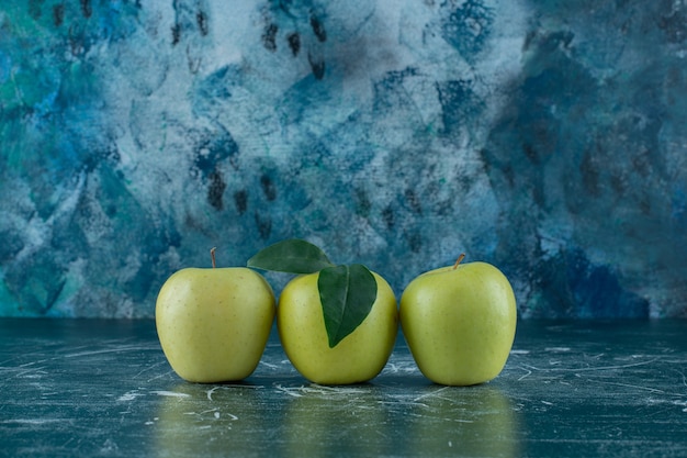 Free photo green ripe apples , on the marble table.