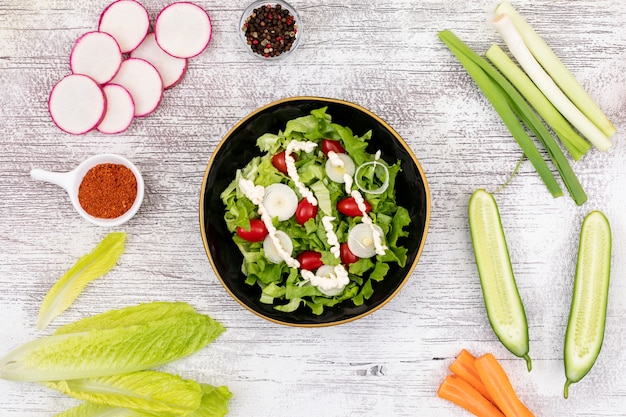 Green salad on the white table top view vegan cuisine