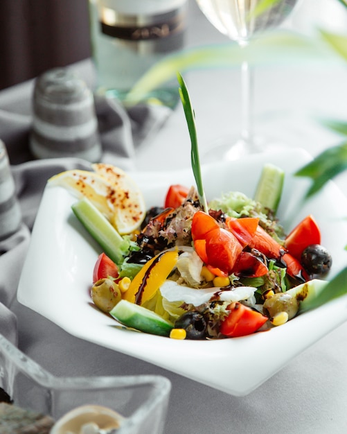 Free photo green salad with lettuce cucumber tomato corn bell pepper and olive