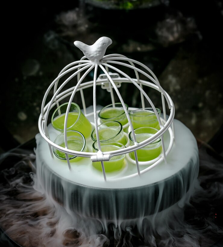 Free Photo green shots in white small cage in smoky bowl