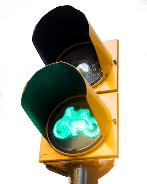 Green signal for bicycles at yellow traffic lights against white background