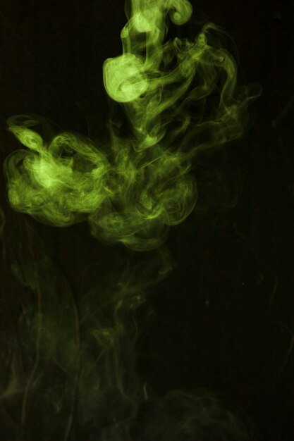 Green smoke fumes on black background