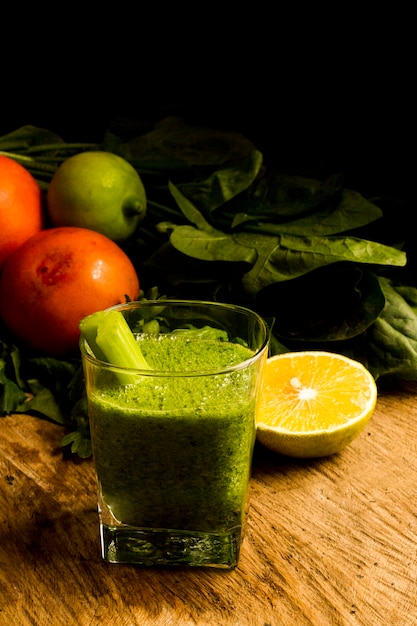 Green smoothie in glass with cut lemon