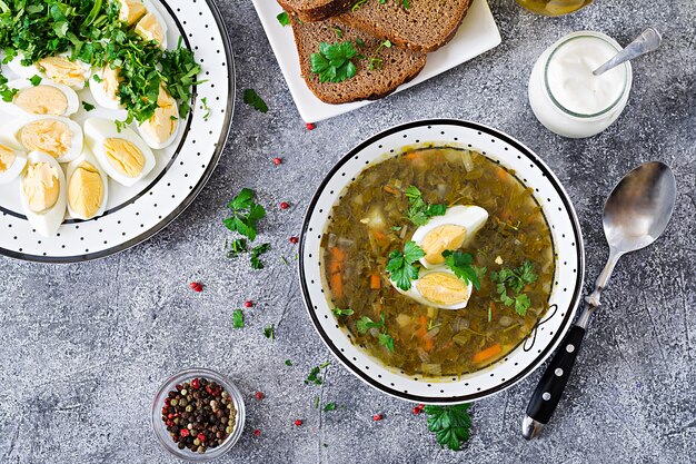 Green sorrel soup with eggs. Summer menu. Healthy food. Flat lay. Top view