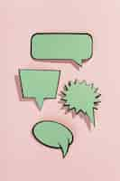 Free photo green speech bubbles with black border on pink background