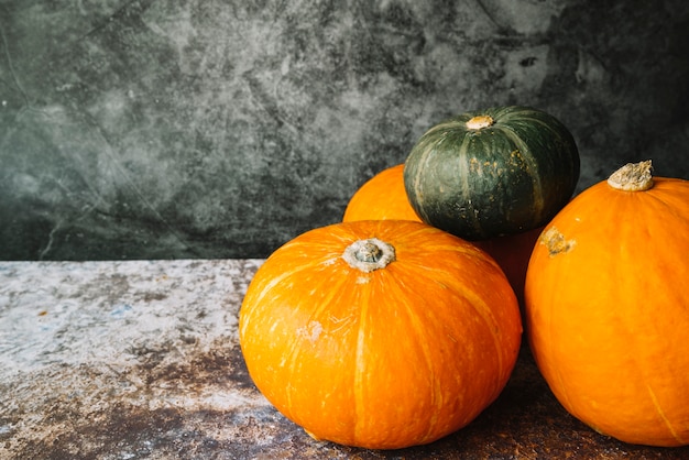 Green squash on orange pumpkins