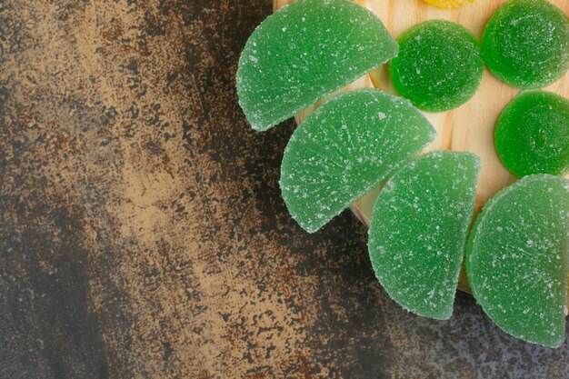 Green sugar sweet marmalade on wooden plate. High quality photo