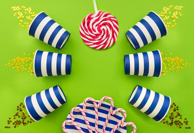 Green surface with lollipop, candy canes and glasses