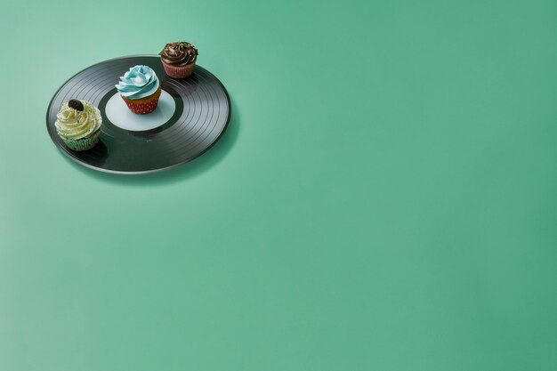 Green surface with vinyl and cupcakes