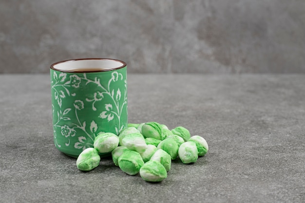 Free photo green sweet candies with a cup of tasty tea