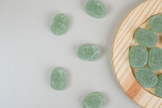 Green sweet jelly candies on wooden plates
