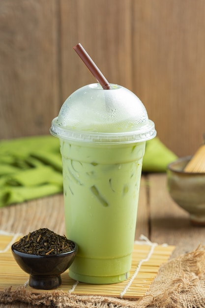 Зеленый чай, молоко со льдом и порошок матча на деревянном полу.