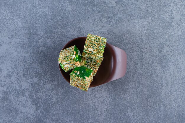 Free photo green turkish delights in a bowl, on the marble background.
