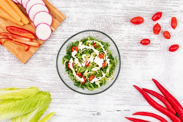 Green vegetable salad in glass plate on the table top view