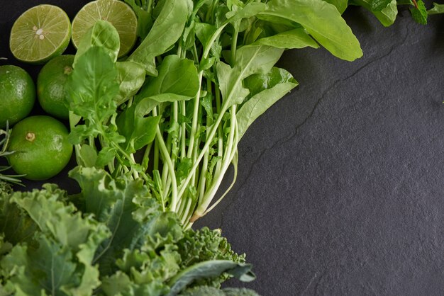 Зеленые овощи и темный листовой пищевой фон как концепция здорового питания свежих садовых продуктов, выращенных органически, как символ здоровья.