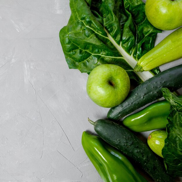회색 배경에 있는 플라스틱 병에 든 녹색 야채와 스무디 건강한 개념 텍스트를 위한 상위 뷰 공간