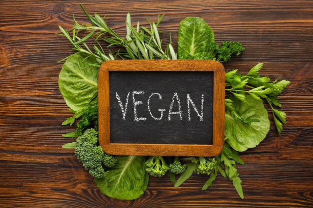 Green veggies with vegan lettering on chalkboard