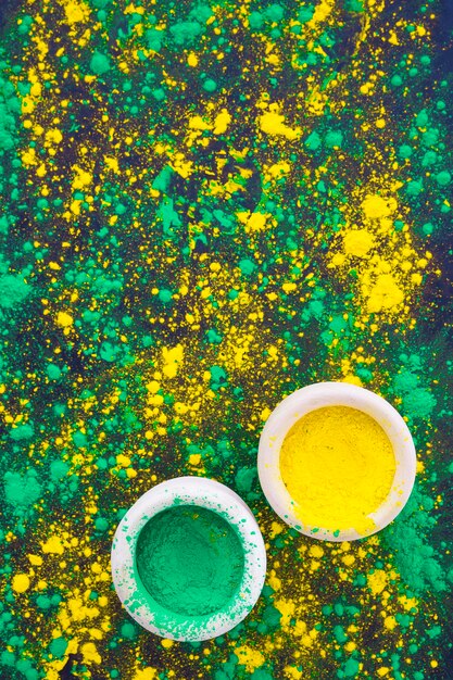 Green and yellow bowl with holi powder