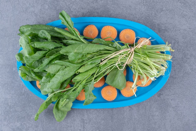 Verde con carote affettate sul vassoio, sulla superficie di marmo.