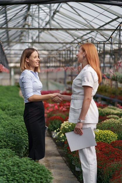 Greenhouse owner presenting flowers options to a potential customer retailer.