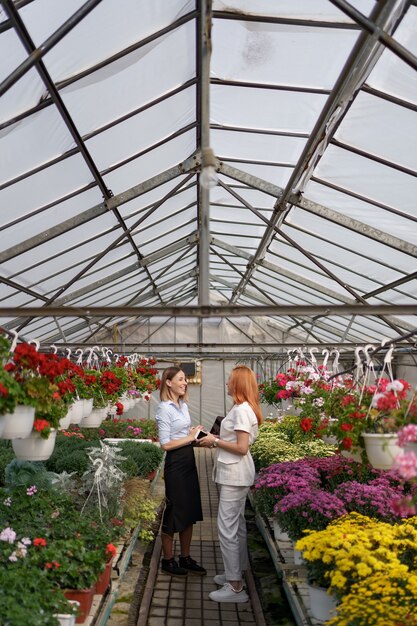 Greenhouse owner presenting flowers options to a potential customer retailer.