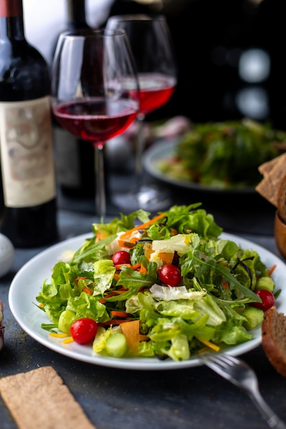 greens vegetables sliced along with red wine inside white plate