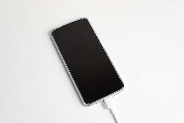 Серый сотовый телефон, подключенный к USB-кабелю типа C - зарядка