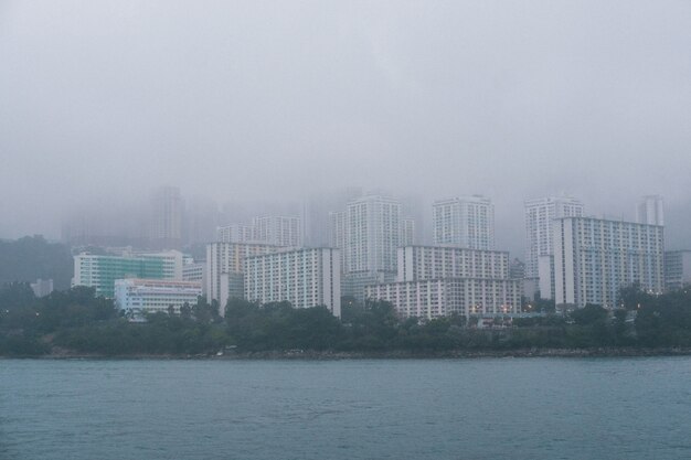 霧深い天候の海岸に灰色のコンクリートの高層ビル